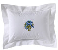 White pillow with floral embroidery on a white background