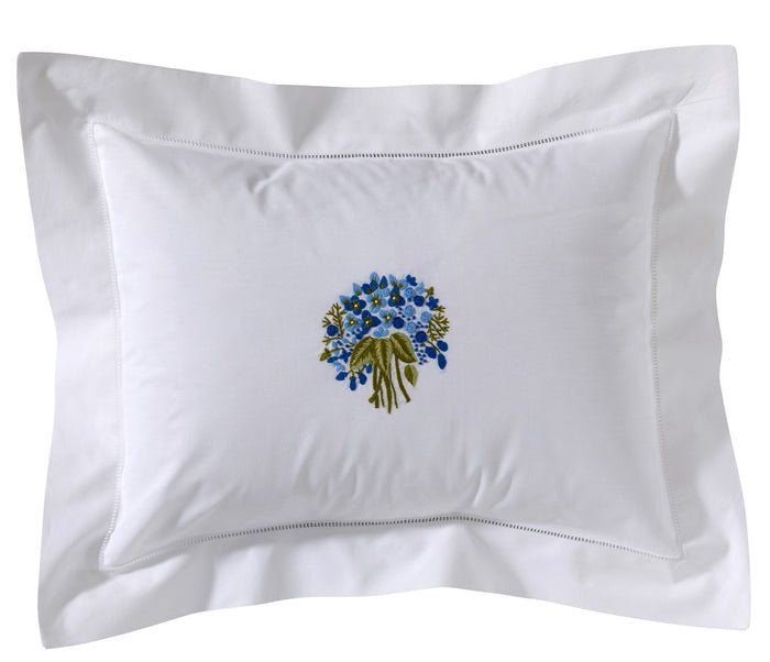 White pillow with floral embroidery on a white background