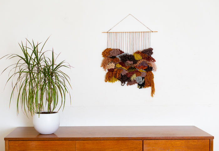Cedarville fiber wall art styled above wood console with indoor plant — Scandinavian-inspired modern statement decor.