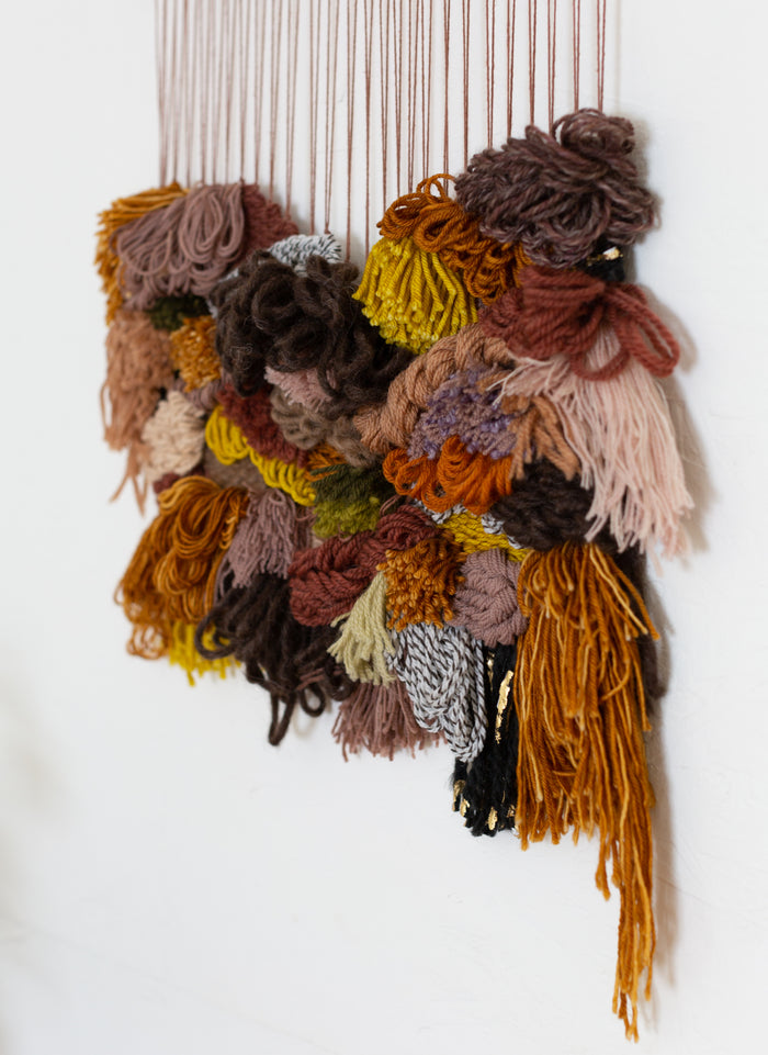 Close-up of Cedarville layered yarn textures — dimensional fiber wall art with rich earthy tones and sculptural detail.