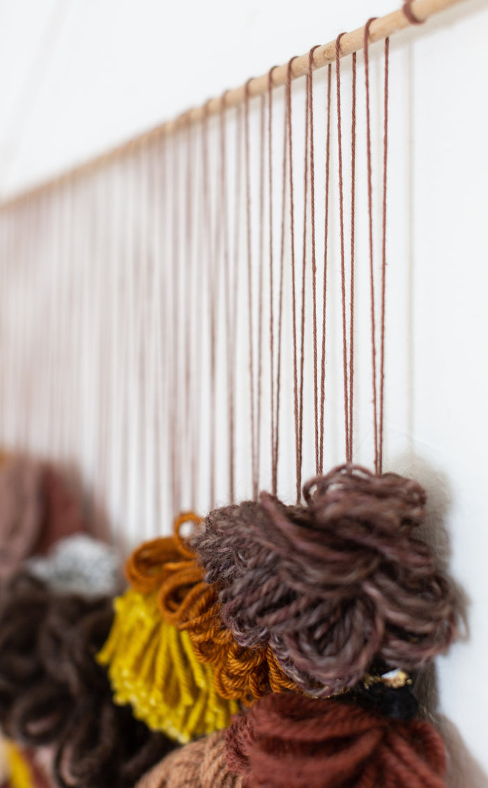 Side angle of Cedarville highlighting vertical hanging cords and textured yarn composition — handcrafted statement wall art.