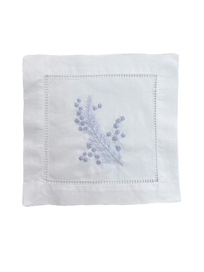 White napkin with blue floral embroidery on a white background