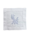 White napkin with blue floral embroidery on a white background