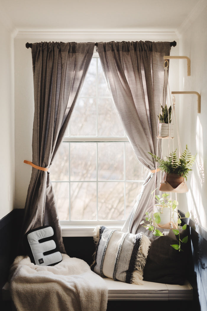 Warm-toned living room with brown drapes secured by Keyaiira leather wall straps — modern farmhouse curtain tie-back detail.