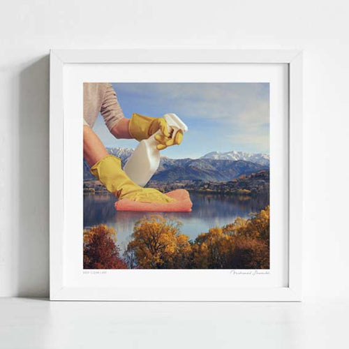 Close-up detail of Deep Clean Lake art print. Gloved hands polishing a scenic lake landscape, thought-provoking surreal nature wall decor for offices and galleries