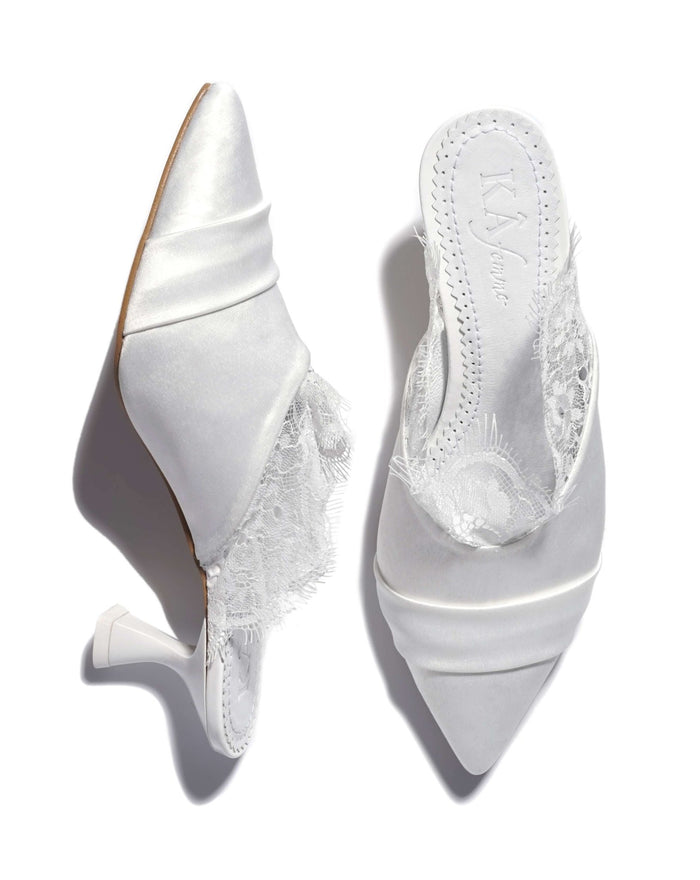 A shot of the slippers on a white background, where one shoe stands and the other lies to show the heel.