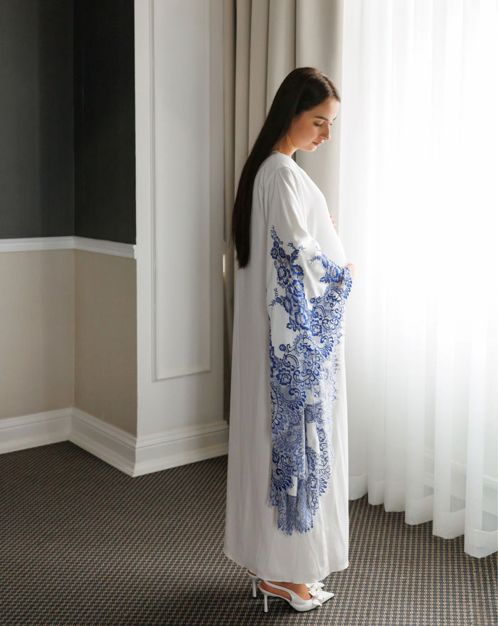 Side full-length pose focusing on the wide sleeves adorned with delicate and intricate lace embroidery.