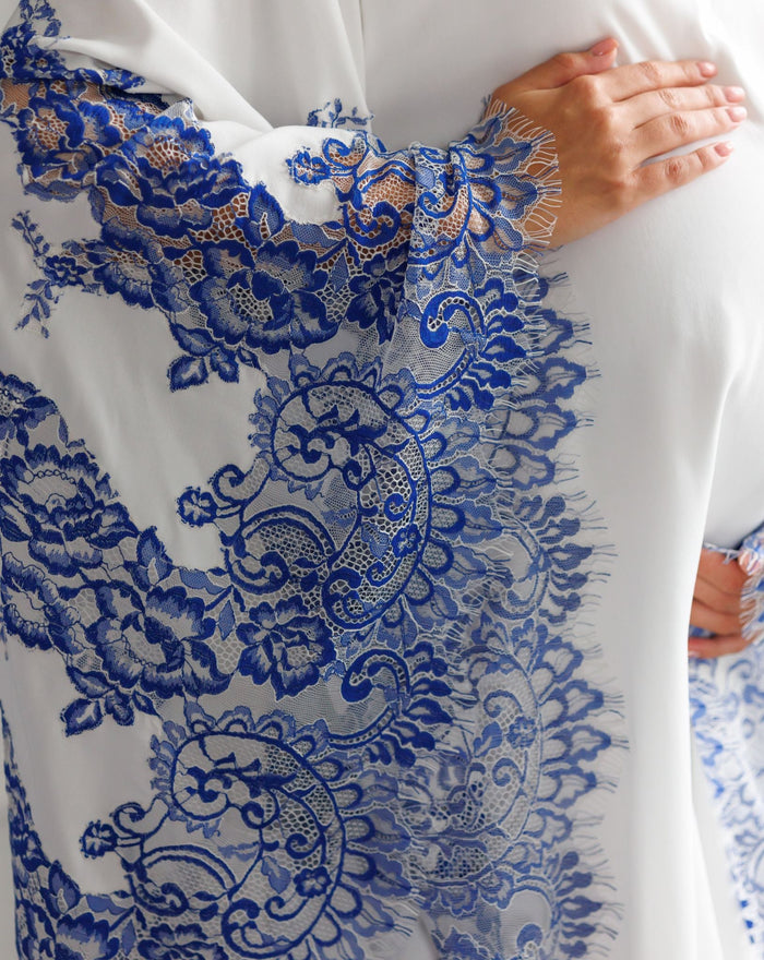 Close-up of hands on a pregnancy bump, showcasing the elegant lace details and high-quality craftsmanship of the sleeves.