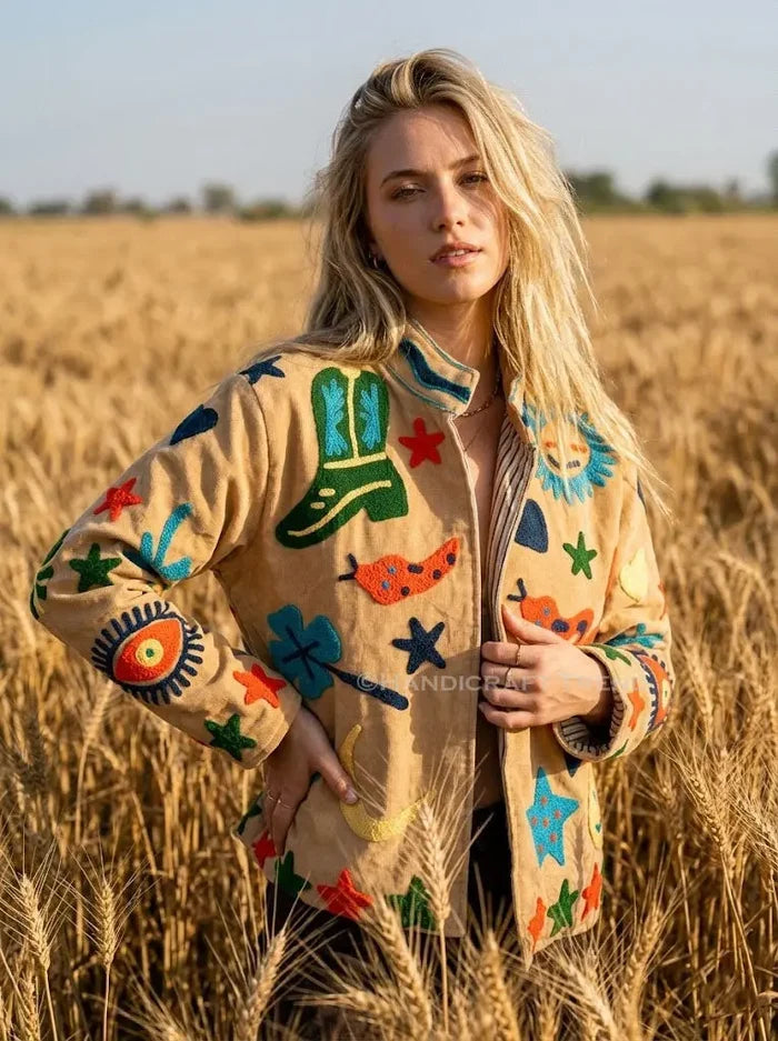 Woman wearing a colorful jacket in a field of wheat