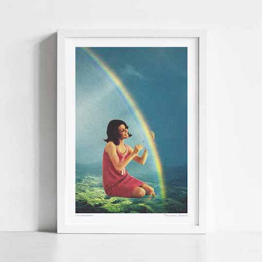 High Maintenance art print framed vertical — surreal vintage painting style of a dark haired 1960s woman in a pink dress kneeling in a lush landscape with a vivid double rainbow filling the dramatic sky above her, romantic dreamy atmospheric art print for living rooms and gallery walls