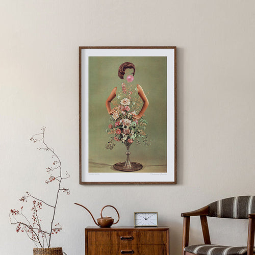 Surreal retro floral art print — a confident 1960s woman with hands on hips, blowing a pink bubblegum bubble, her torso a silver pedestal vase bursting with blush roses, cream peonies and trailing wildflowers against a sage green background, kitsch botanical fashion wall art by Vertigo Artography