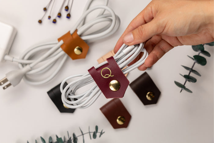 Custom leather charger cord holders in multiple colors, handmade by Keyaiira for organizing charging cables, electronics cords, USB cables and everyday desk or travel accessories