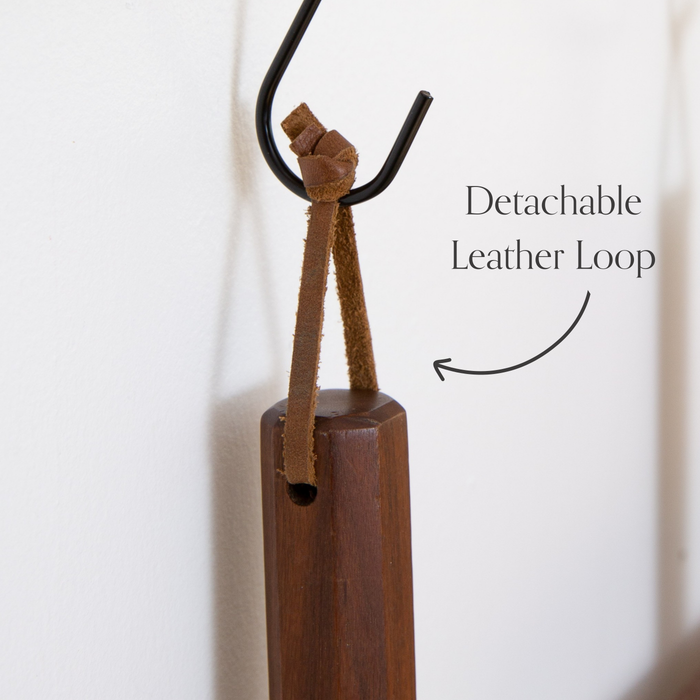 Detachable leather hanging strings by Keyaiira shown hanging from a wall hook, highlighting the removable leather string design with brass screw hardware.