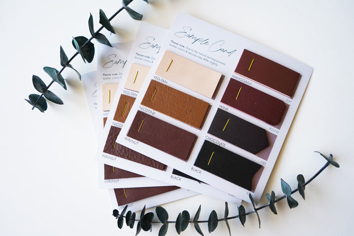 Keyaiira Leather Swatch Card  hand holding a sample card featuring natural veg-tan, chocolate, black, and wine leather colors. Handmade leather color reference for Keyaiira pulls and hardware pieces.