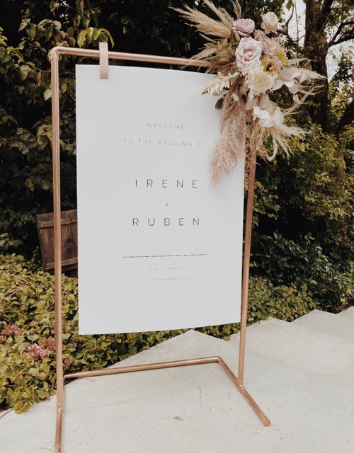 Keyaiira leather signage hanger holding a wedding welcome sign on copper frame sustainable event decor.