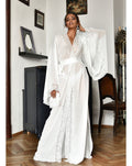 Woman wearing a flowing chiffon robe standing next to a piano