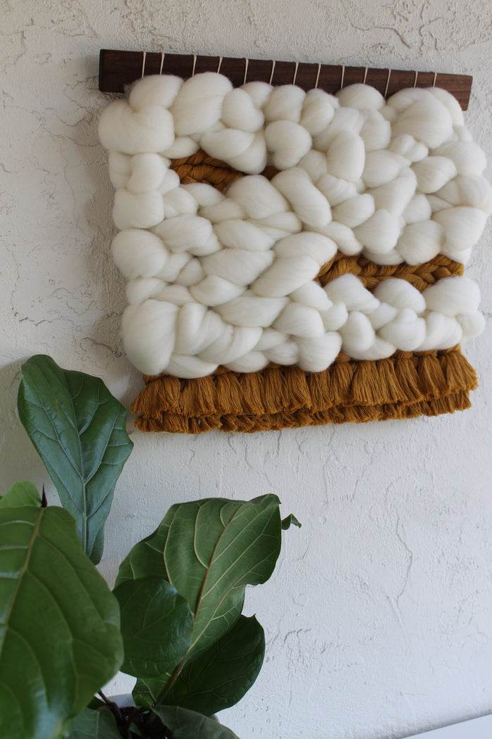 Keyaiira handcrafted fiber wall hanging made from natural wool and cotton, featuring chunky white weaving and warm brown fringe in modern organic home decor