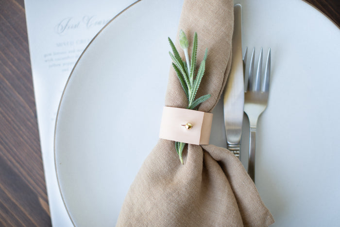 Designed and crafted by Keyaiira, this veg-tan leather napkin ring with brass stud detail brings refined simplicity to any table setting. Styled here with a beige linen napkin for a clean modern look.