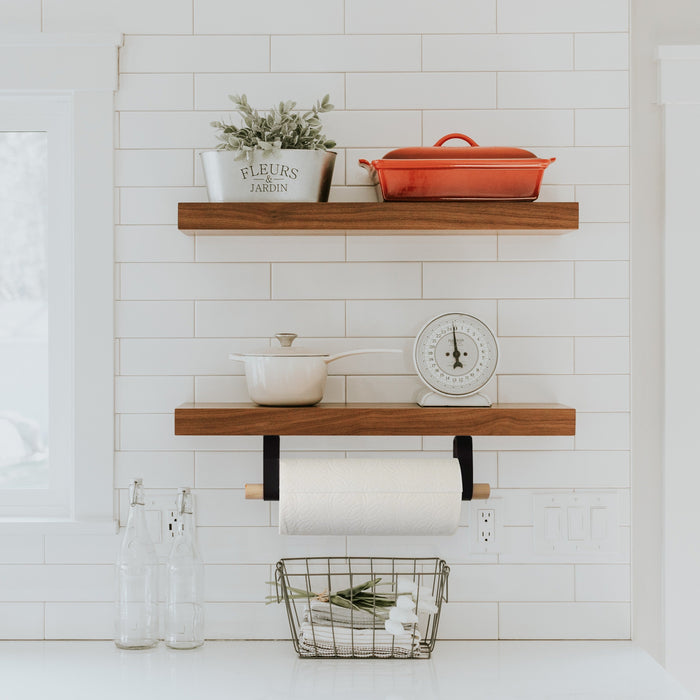 Wall-mounted paper towel holder with leather straps and wood dowel — modern farmhouse kitchen organizer with black leather brackets and minimalist design.