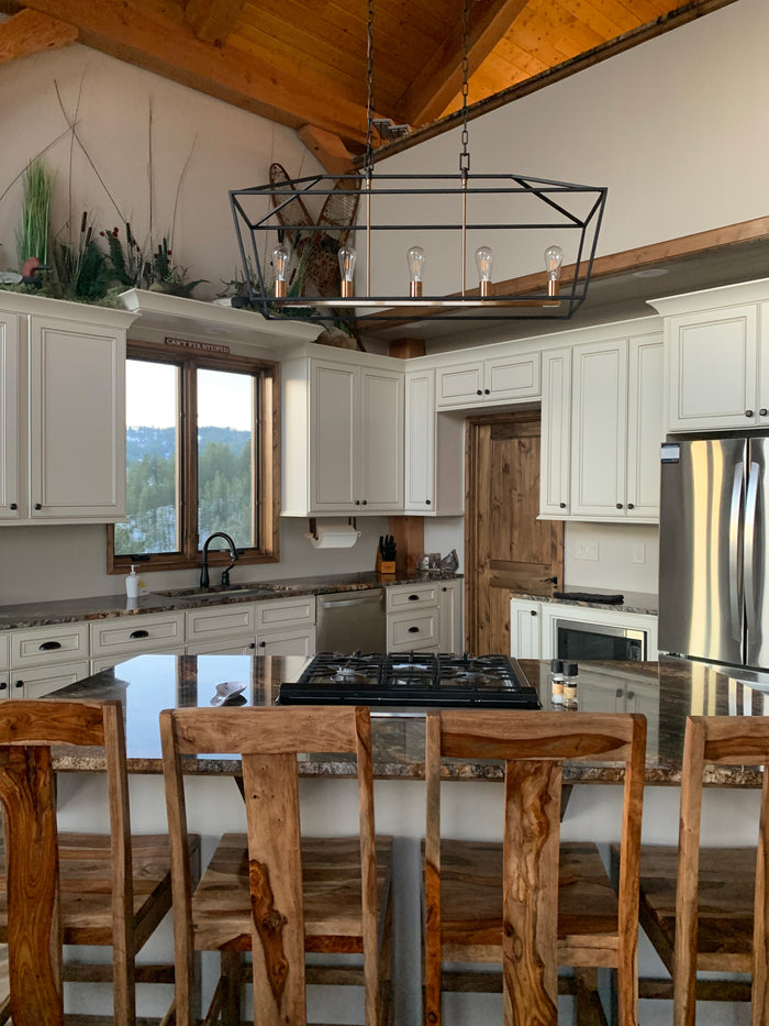 Open-concept kitchen featuring leather strap paper towel holder — modern rustic wall-mounted storage accessory.