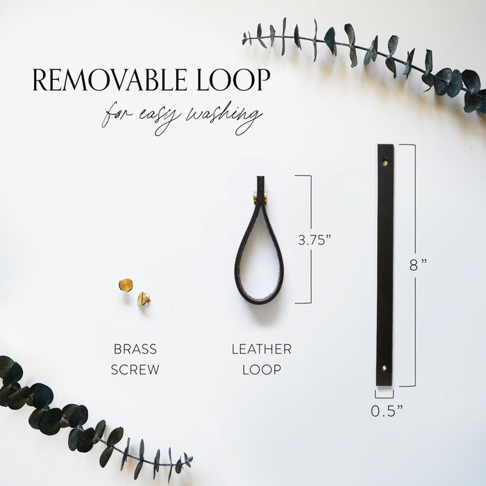 Removable leather strap hanger detail for woven cotton potholder — adjustable hanging loop with brass hardware for kitchen organization.