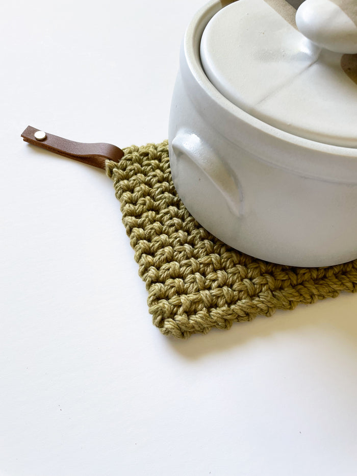 Olive green cotton potholder with leather strap detail — thick woven hot pad designed for cast iron and everyday cooking.