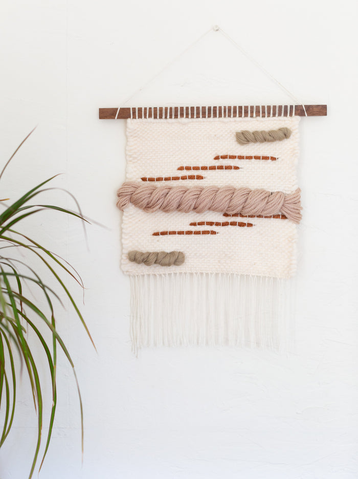 Textured fiber wall tapestry styled in minimalist interior — handcrafted woven wall decor with neutral and terracotta accents.