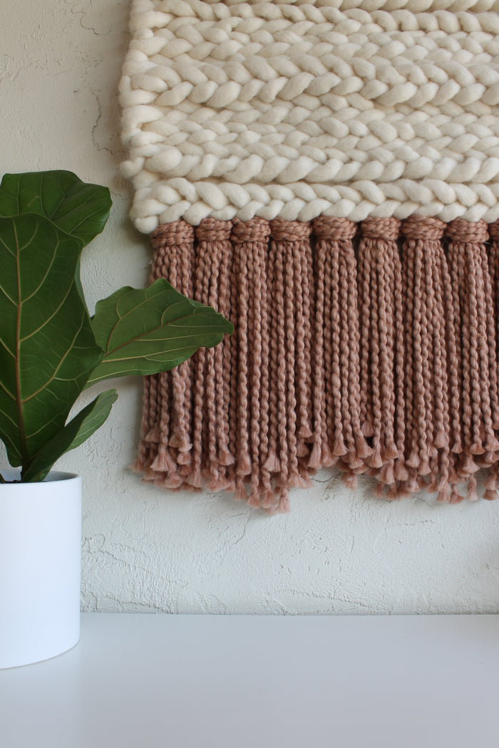 Close-up of Keyaiira wall hanging showcasing hand-tied mauve fringe with soft flowing fibers, highlighting texture, movement, and handcrafted wool detail