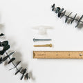 Screw and wall anchor set with zinc and brass screw options, plastic drywall anchor, and size reference ruler — mounting hardware for leather wall straps, towel rings, and suspended storage systems.