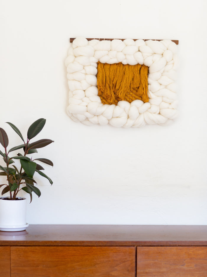 Contemporary interior featuring Sesame Cloud wall art above mid-century dresser — organic modern handcrafted fiber decor.