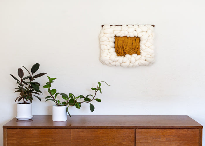 Minimalist living space styled with Sesame Cloud fiber wall hanging — small modern textile art with natural materials.