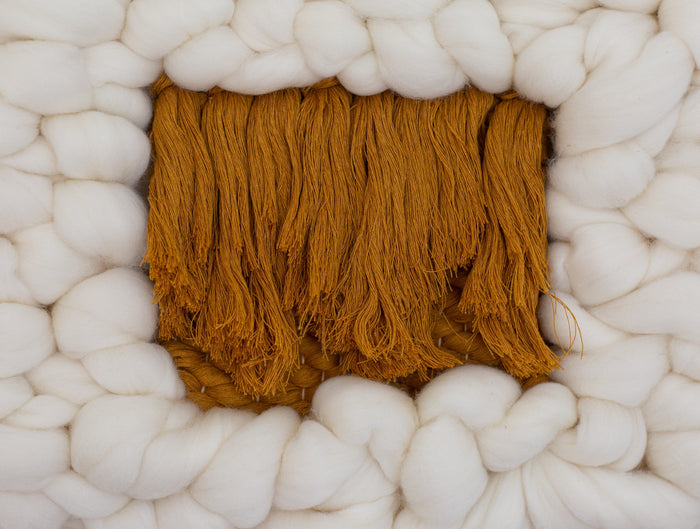 Detailed close-up of Sesame Cloud mustard center panel — textured woven yarn surrounded by plush cream wool.