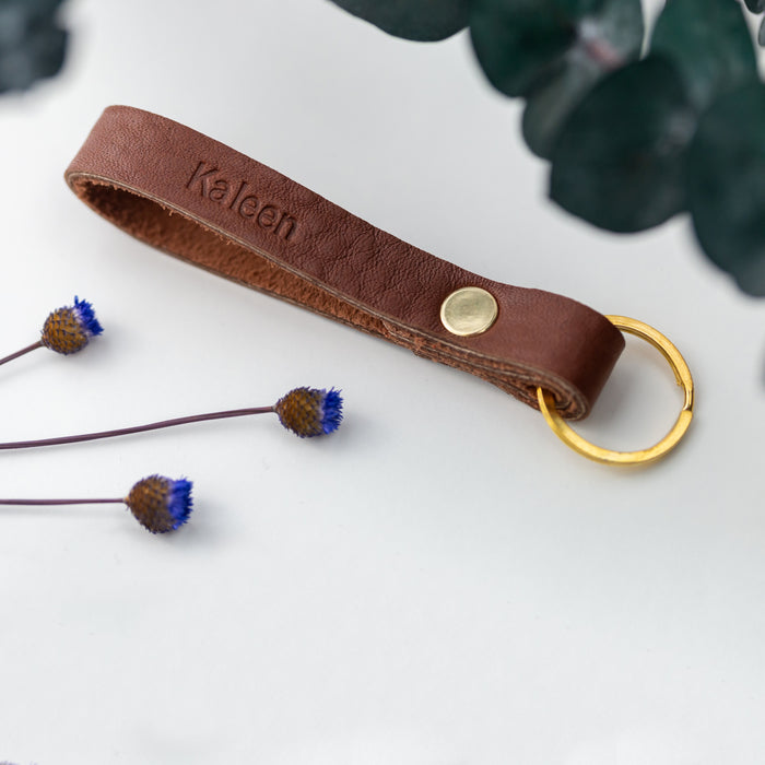 Skinny leather loop keychain with brass ring and snap closure — minimalist personalized key fob in warm brown leather.
