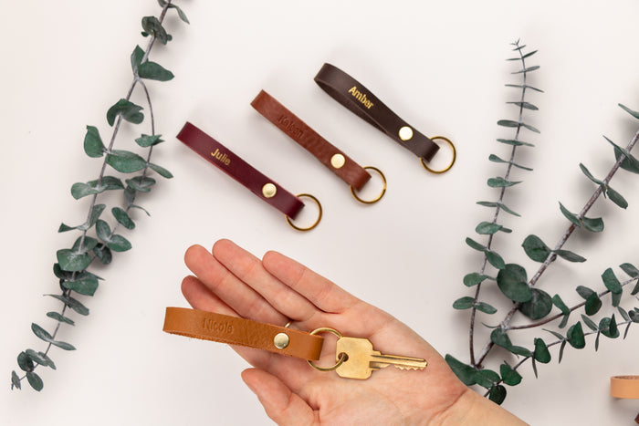 Personalized skinny leather keychains in multiple colors — custom engraved key fobs with gold-tone ring hardware.