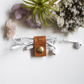 Handcrafted leather earbud cord holder with customized F initial and brass snap, compact Keyaiira cable organizer for wired headphones, charging cords, small electronics and tangle-free storage