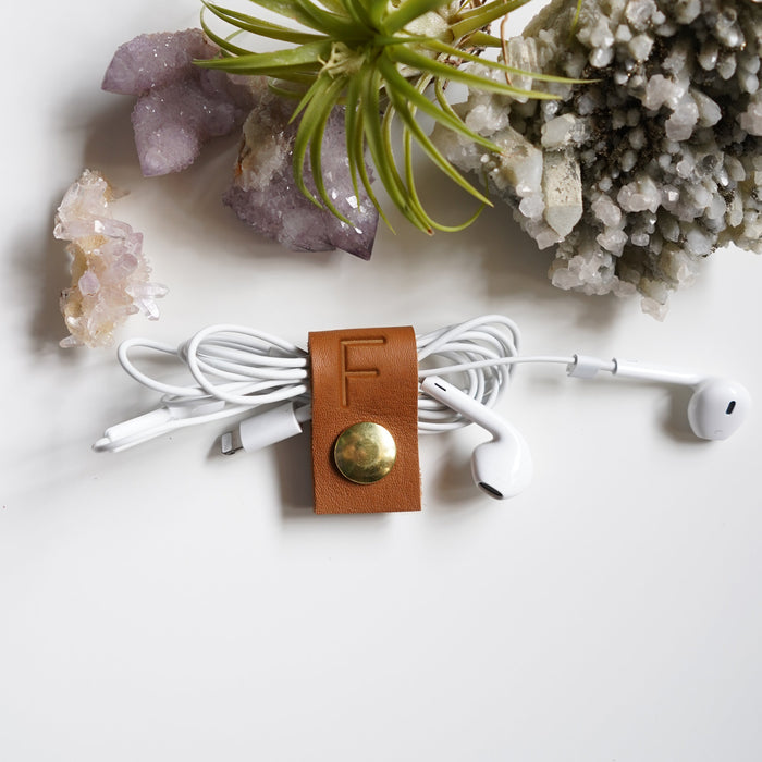 Handcrafted leather earbud cord holder with customized F initial and brass snap, compact Keyaiira cable organizer for wired headphones, charging cords, small electronics and tangle-free storage