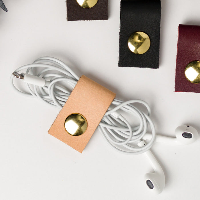 Veg Tan genuine leather earbud organizer with brass snap closure, artisan-made Keyaiira cord wrap for wired headphones, charging cables, small electronics and tangle-free travel storage