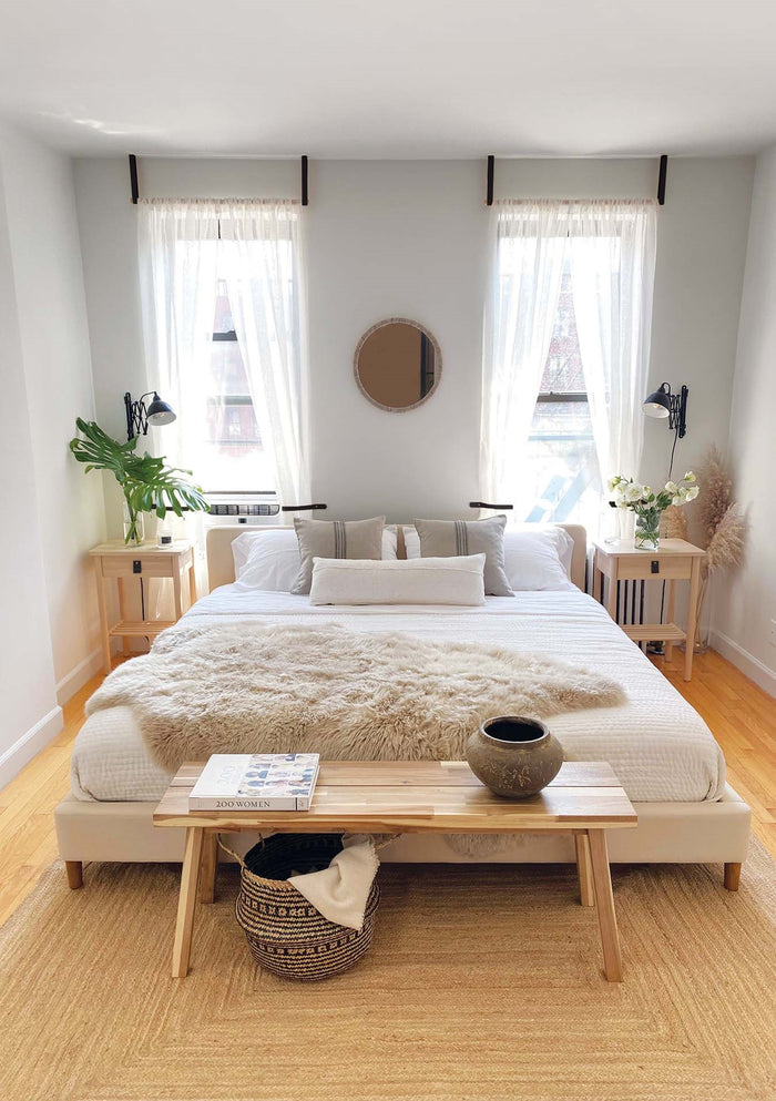 Modern bedroom scene featuring two walnut bedside tables fitted with a Keyaiira small wide leather pull, styled with neutral bedding and minimalist décor.