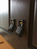Keyaiira black leather wall straps mounted on dark wood cabinet doors with solid brass hardware, modern minimalist leather cabinet hooks for kitchen or bathroom organization.