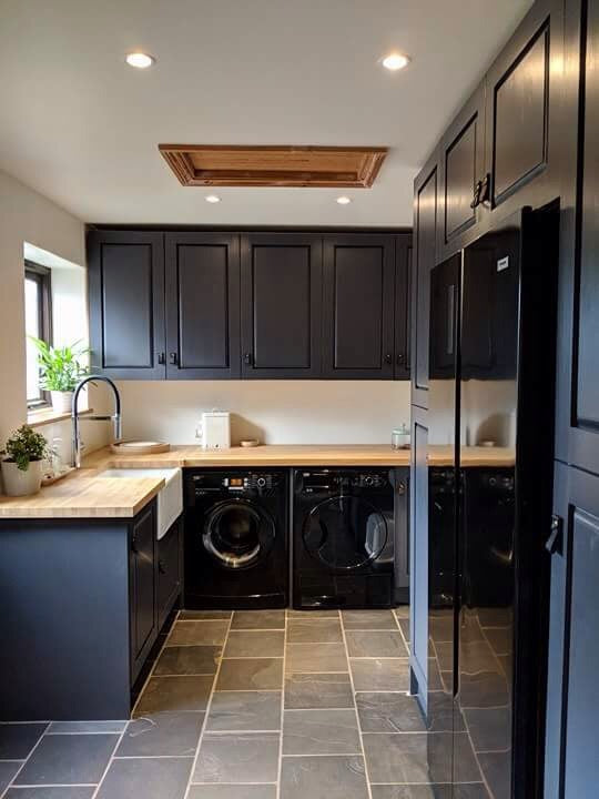Modern laundry room with black cabinetry featuring Keyaiira leather pulls handcrafted vegetable-tanned leather hardware adds warmth and contrast to sleek black cabinets.