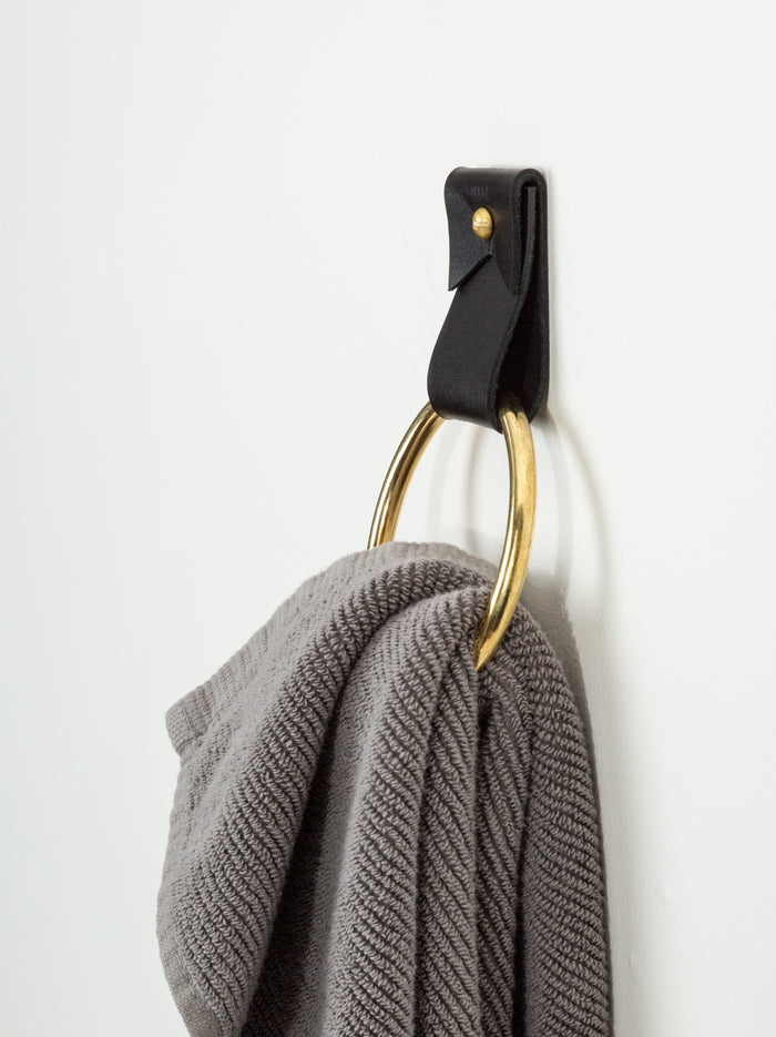 Keyaiira Black Leather Towel Ring holding a gray waffle towel handcrafted wall strap with brass hardware for modern, minimal bathroom storage.