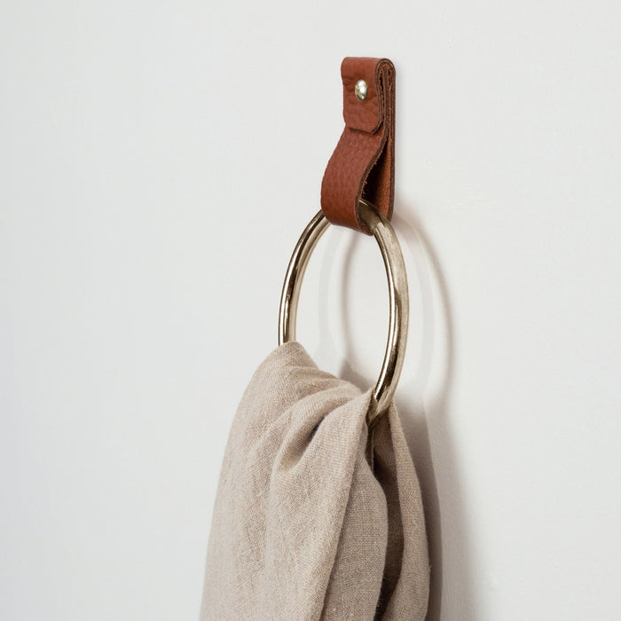 Modern towel ring with leather strap and brushed silver finish, handcrafted hardware for kitchen or bath organization.