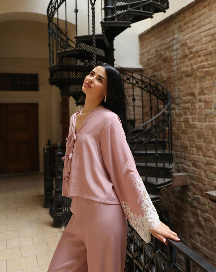 A mid-length shot of a woman leaning against a railing, highlighting the soft and fluid drape of the viscose fabric.