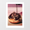 Surreal Decadent Donut art print — giant glazed donut in a desert landscape with dramatic figures draped across it and chocolate sauce pouring from above, surreal food wall art for kitchens and eclectic interiors