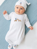 Baby wearing a white outfit with floral embroidery on a blue blanket
