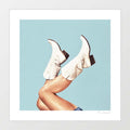 Contemporary art print of white embroidered cowgirl boots with legs kicked in the air against a clear sky blue background – These Boots Blue by Vertigo Artography