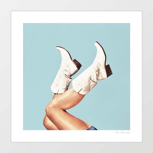 Contemporary art print of white embroidered cowgirl boots with legs kicked in the air against a clear sky blue background – These Boots Blue by Vertigo Artography