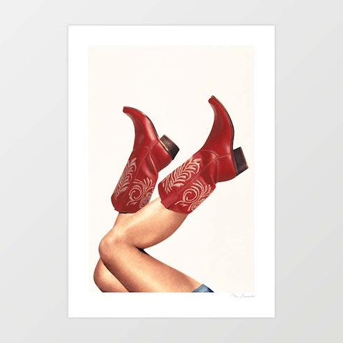 These Boots Rouge art print — bare tanned legs crossed at the ankle wearing deep burgundy rouge cowboy boots with intricate blush cream embossed feather and botanical scroll tooling across the shaft and dark brown stacked heel against a pure warm ivory background, luxury western glamour artisan leatherwork fashion art print for boutique hotel boudoir dressing room and fashion interior decor