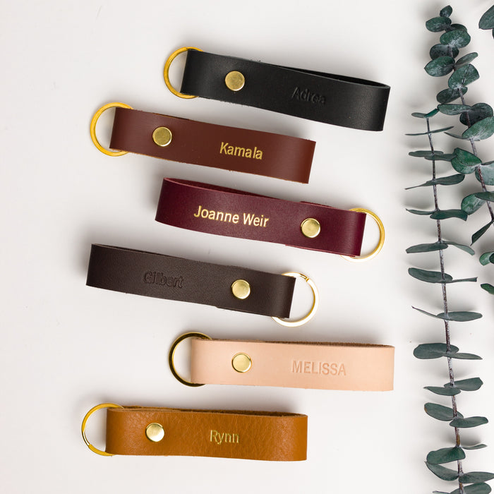 Color selection of thick leather loop keychains — custom engraved key holders in warm neutral and bold tones.