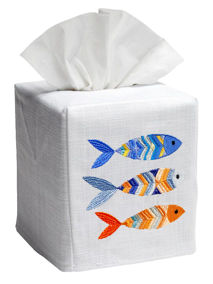 A white tissue box cover with a multicolor fish pattern, displaying three embroidered fish designs on the front.